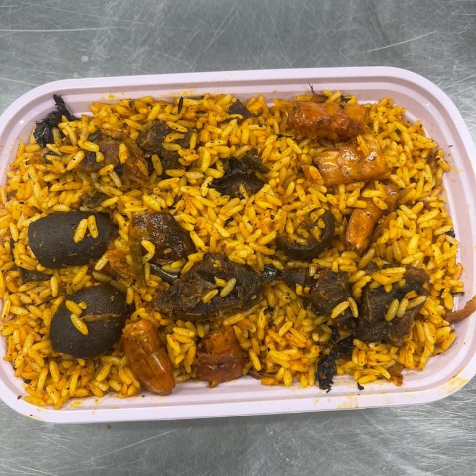 Arona Food Place's Nigerian jollof rice with meat, mushrooms, and plantains in a white container.