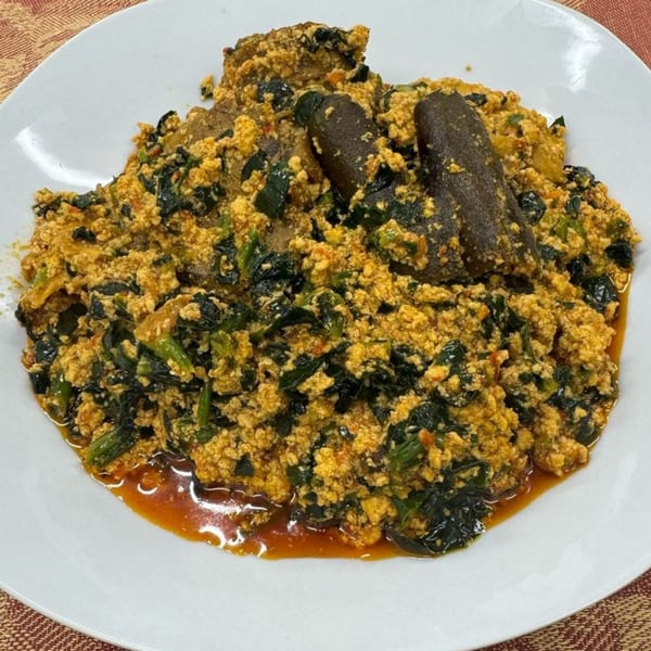 Arona Food Place's Nigerian Egusi soup with dark green vegetables and two pieces of meat.