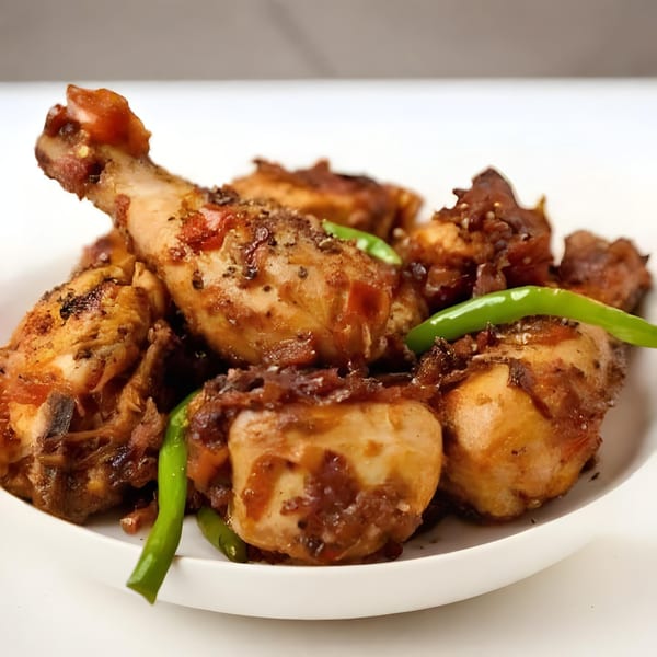 Arona Food Place's Nigerian fried chicken pieces with green chilies on a white plate.