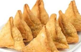 A plate of golden-brown, crispy samosas arranged in a row.