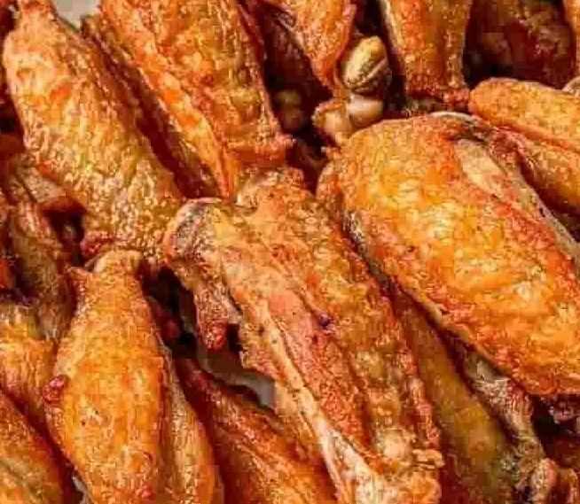 Close-up of a pile of golden-brown crispy chicken wings.